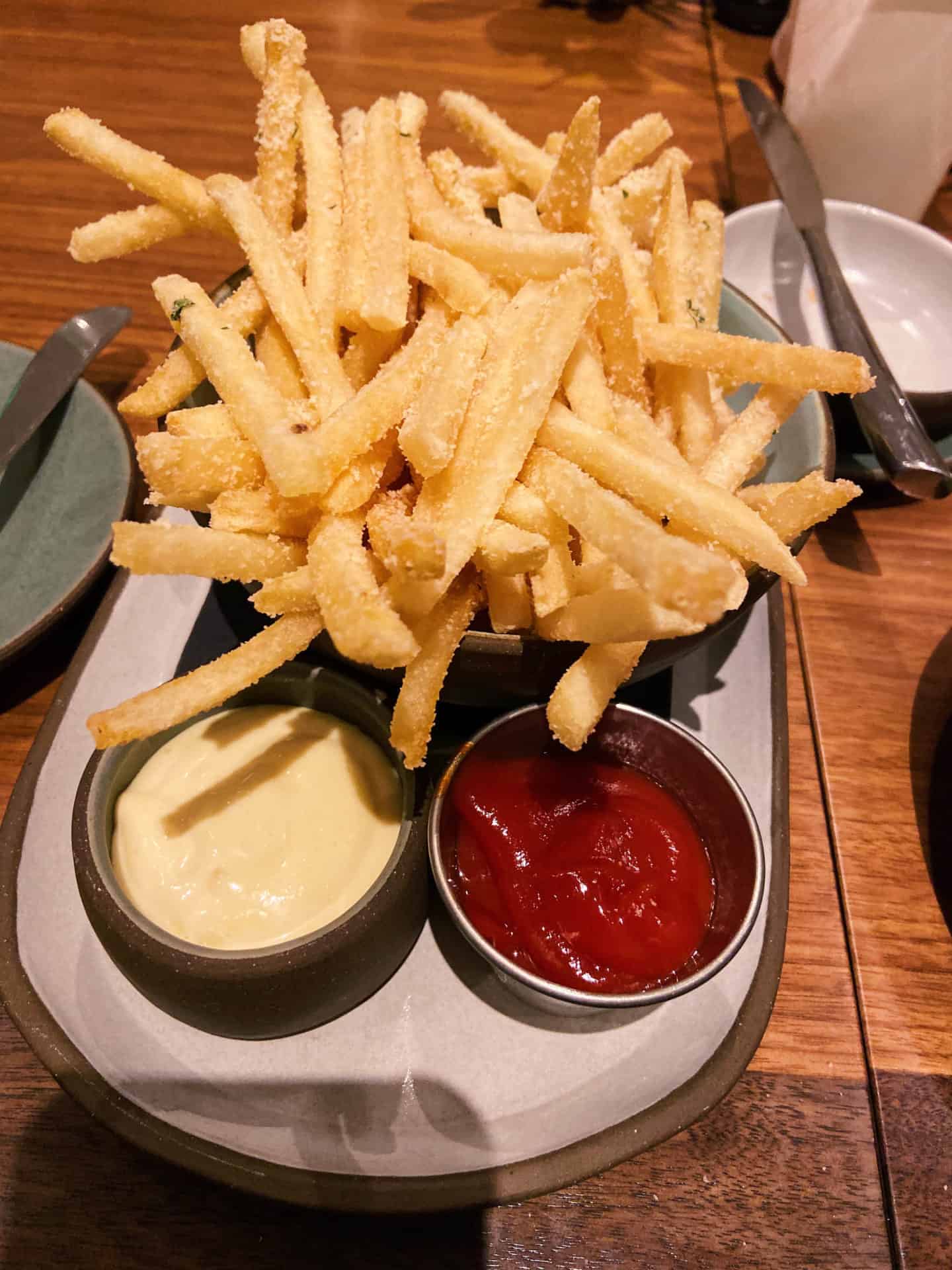 French fries mound high with catsup and mayonaise nearby at the Barn restaurant in the Williams Inn.