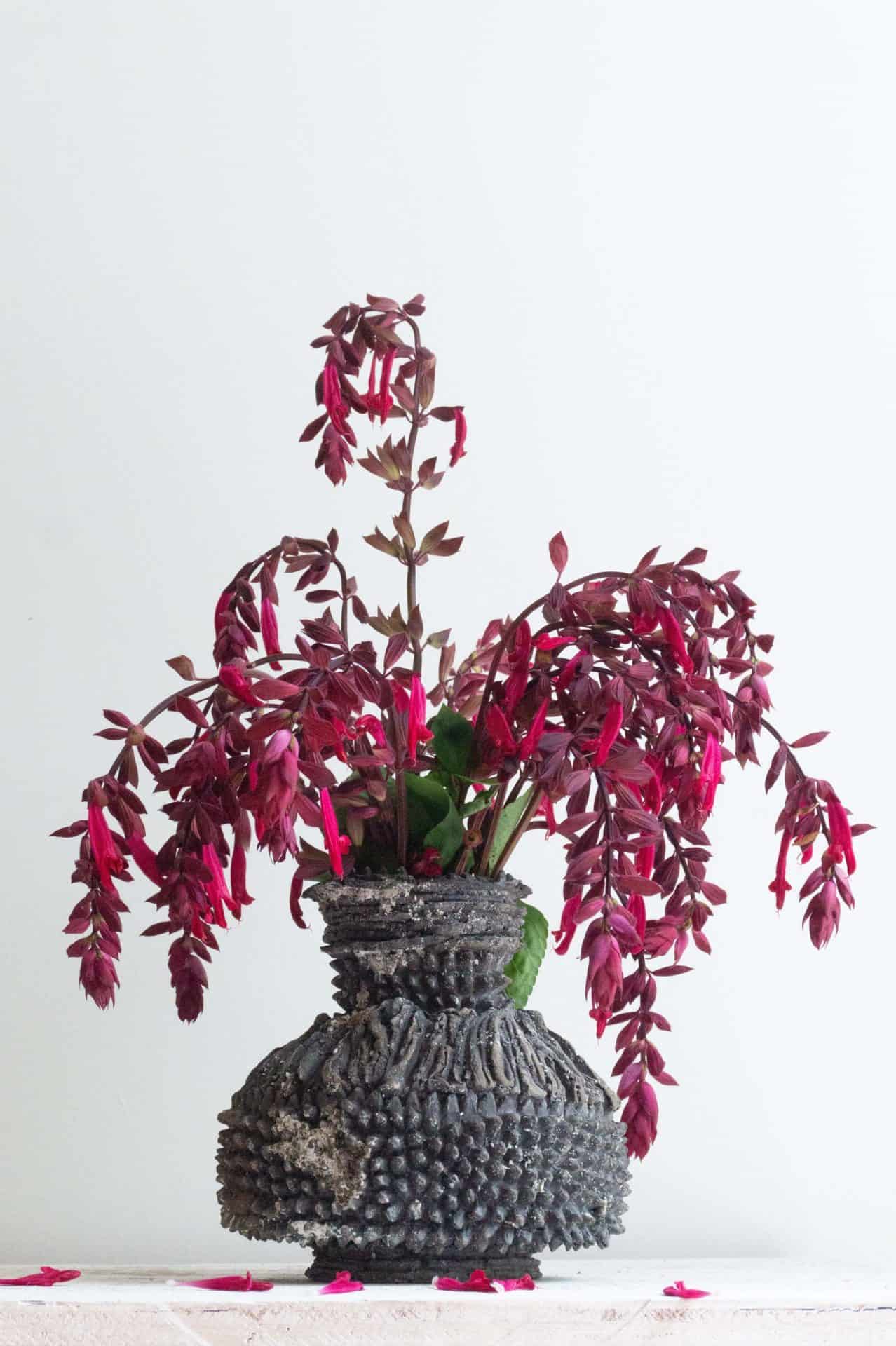 Karlene Kantner's clay vessel 'Easter Dress' holds red blossoms on arced stems.