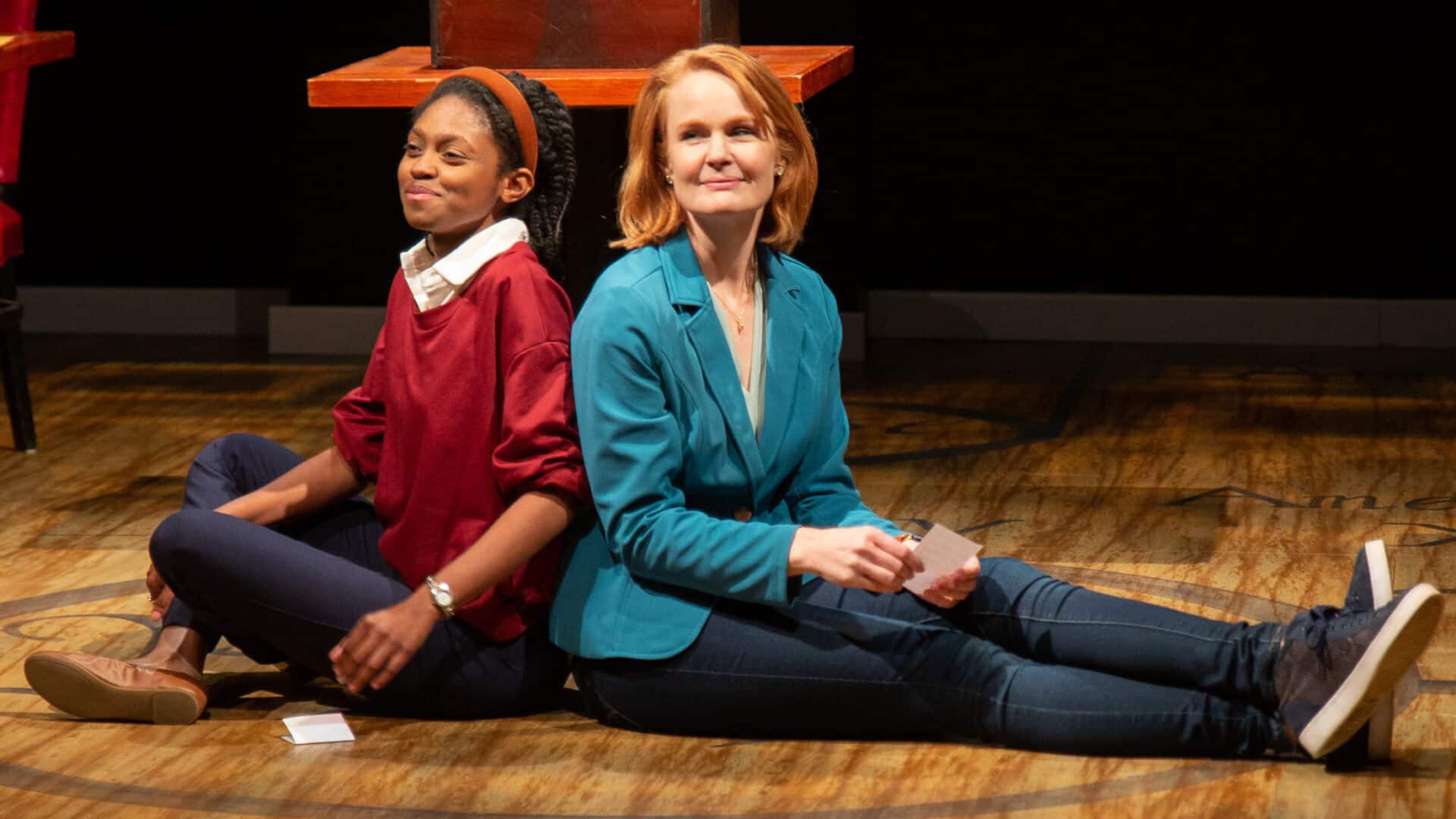 Zurie Adams and Kate Baldwin sit back to back in WAM Theatre's production of What the Constitution Means to Me. Press photo courtesy of WAM Theatre