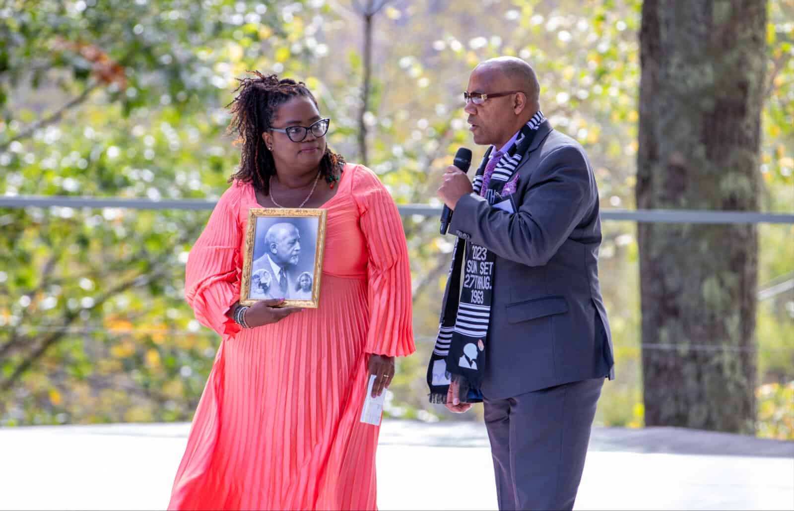 Jeffrey Allen Peck, great grandson of W.E.B. DuBois, gives a photograph of his family to Gwendolyn Van Sant, founder of BRIDGE, on the outdoor stage at Jacob's Pillow. Press photo courtesy of BRIDGE