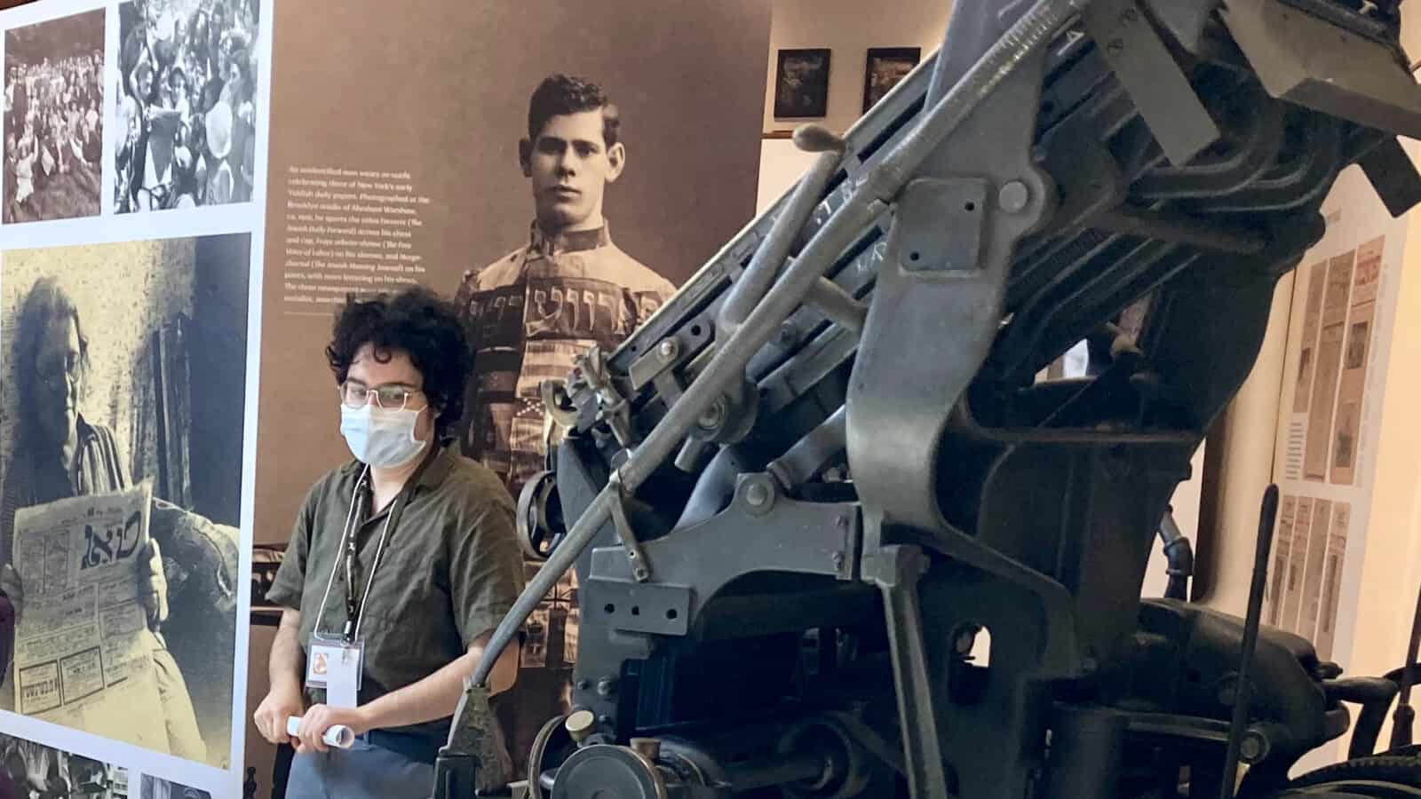 A visitor looks at the last Yiddish linotype machine, on view at the opening of A Global Culture. Press photo courtesy of the Yiddish Book Center in Amherst.