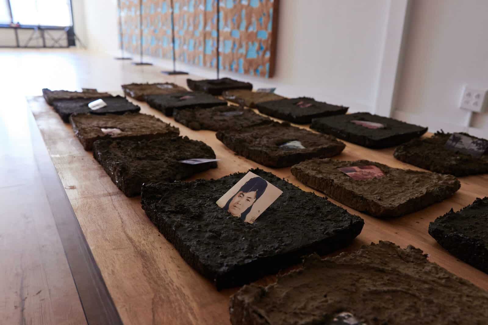 LaRissa Rogers sets family photographs into earth tiles in 'Unfortunately It Was Paradise' at MCLA in North Adams.