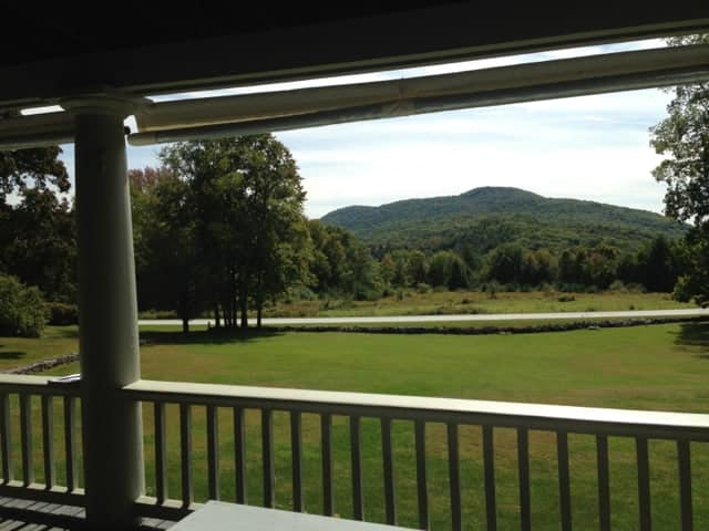 From the porch outside the studio the lawns slope down towards open fields and a view of the mountains. Photo by Kate Abbott