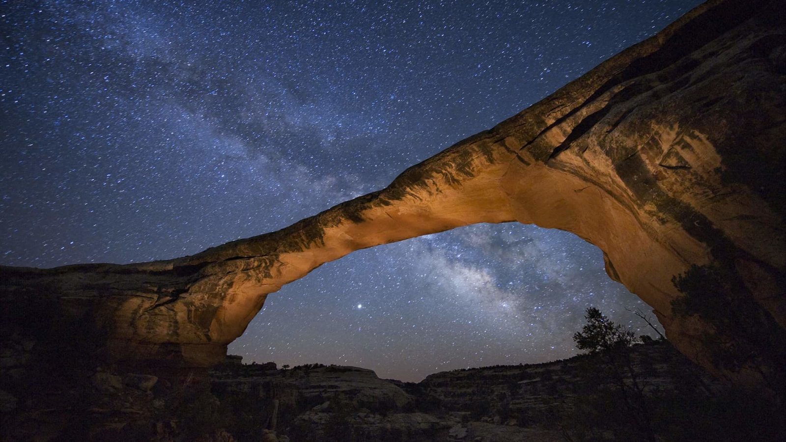 A starry night gleams above Owachomo Bridge at Natural Bridges National Monument, Utah, 2008. Photo by Jim Richardson/ National Geographic Stock. Part of the exhibition National Geographic Greatest Photographs of the American West.