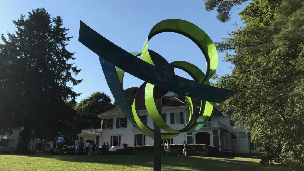 The green loops and blue lines of a Pedro S. de Movellán kinetic sculpture appears in the annual contemporary show at Chesterwood, in summer 2018.