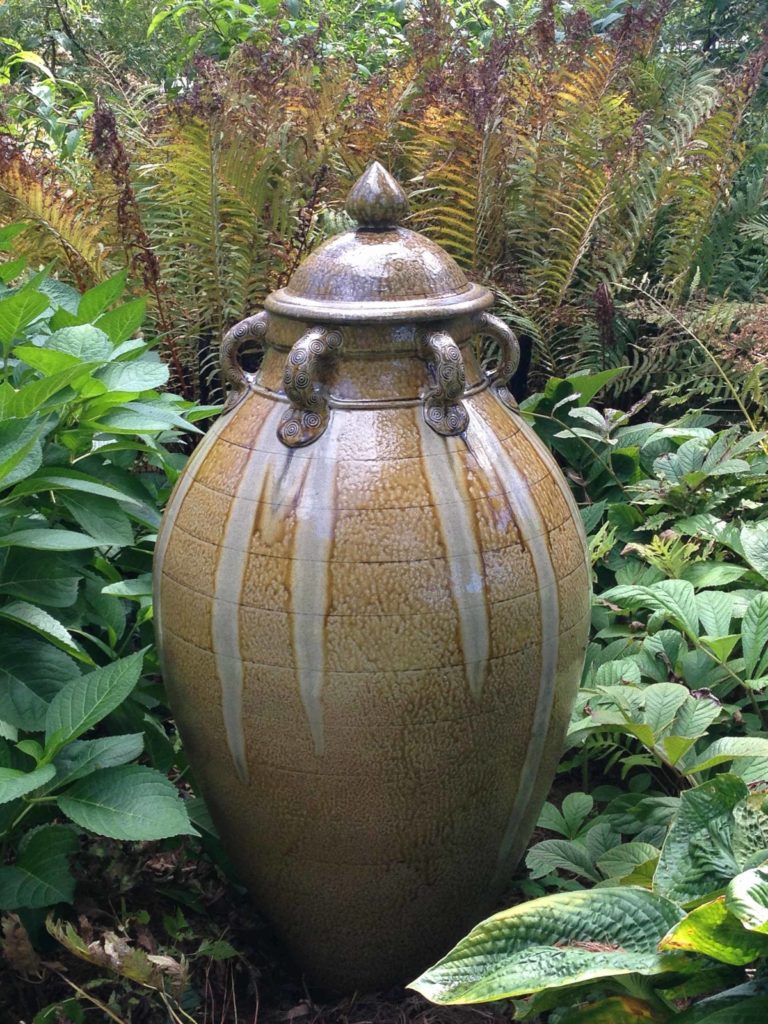 Mark Hewitt's ceramic urn, almost man-high, glows in the ferns at Berkshire Botanical Garden on a fall day.