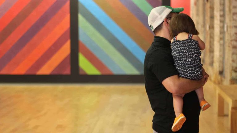 Visitors take in the bright color of Sol Lewitt's murals at Mass MoCA.