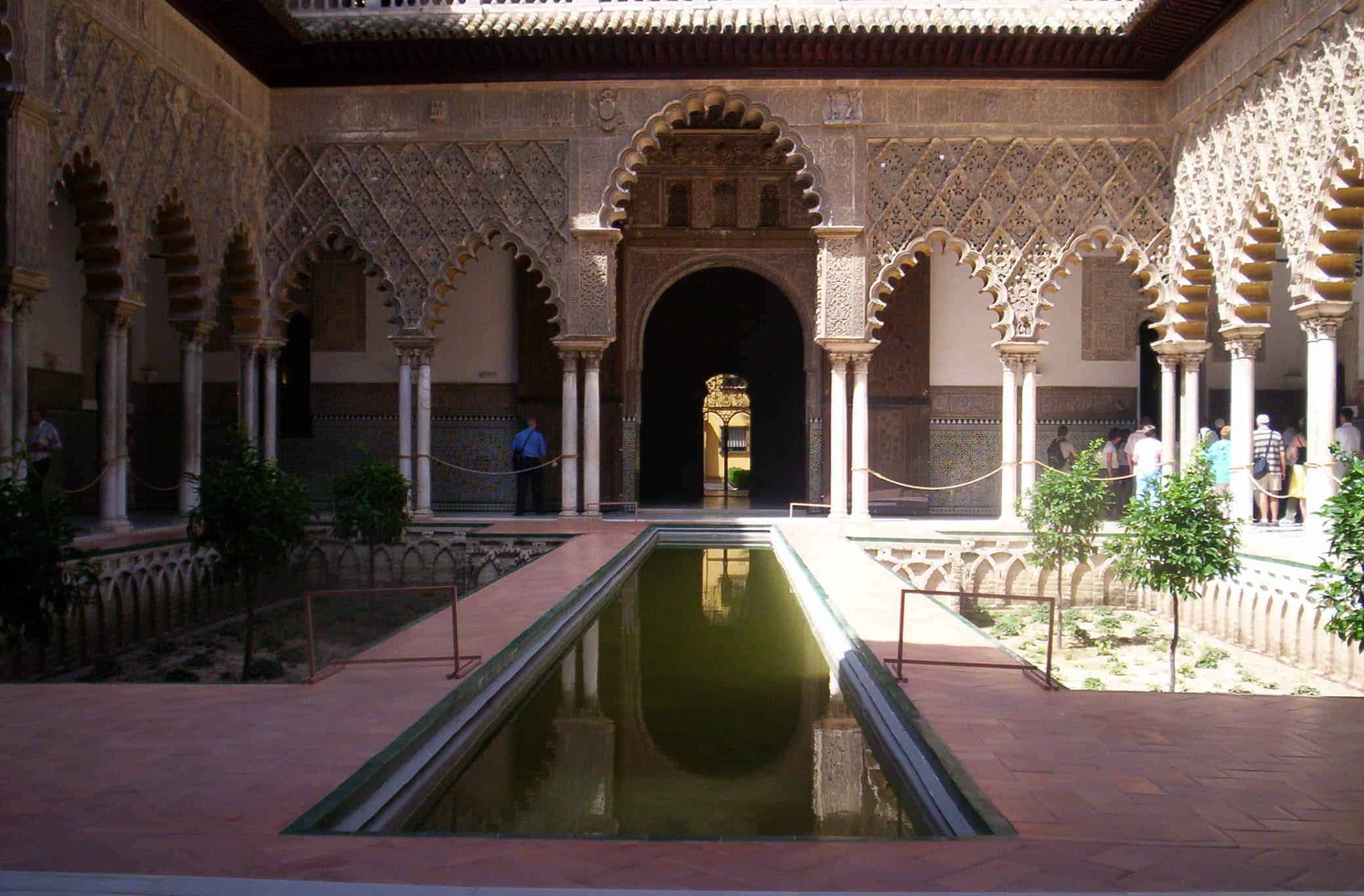 A pool gleams in the courtyard in the Alcazar in Seville.
