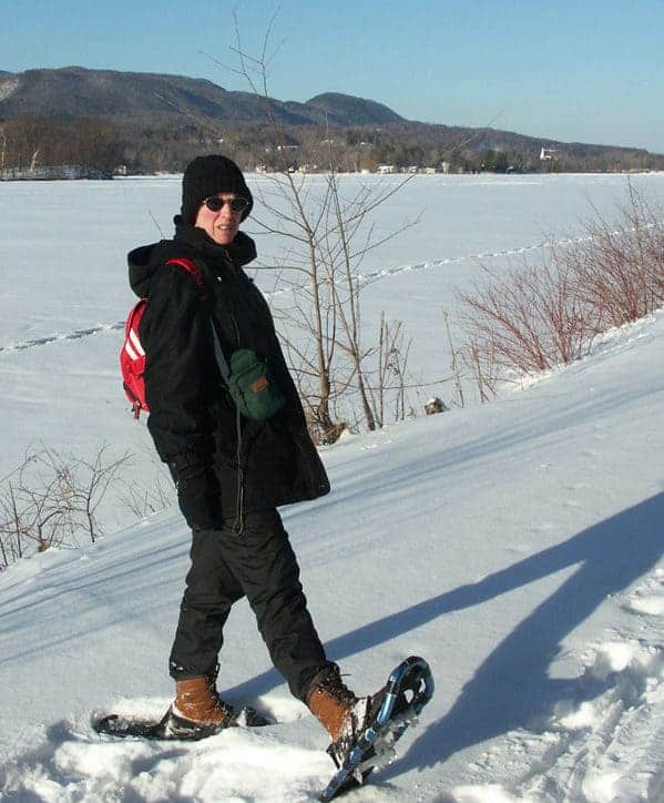 Susan Smith snowshoes along the sunny Ashuwillticook bike trail at Cheshire Lake.