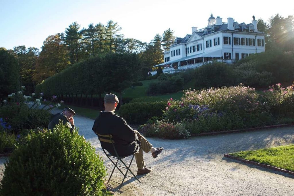 Visitors sit in Edith Wharton's garden at sunset, at The Mount in Lenox.