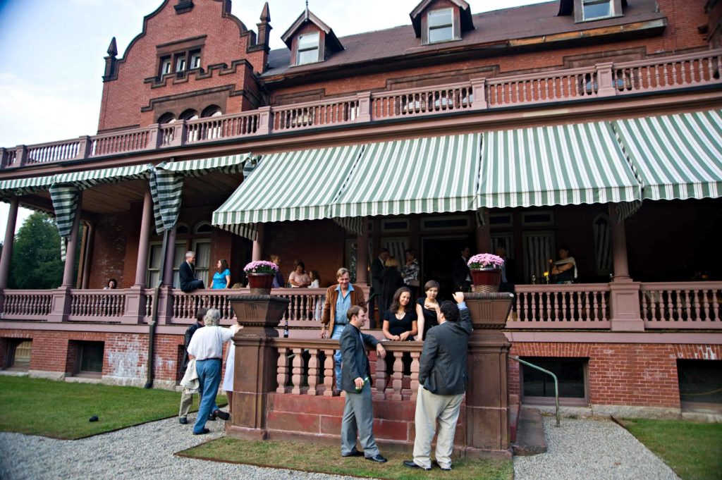 Visitors gather on the porch at Ventfort Hall. Photo by Kevin Sprague, courtesy of Ventfort Hall