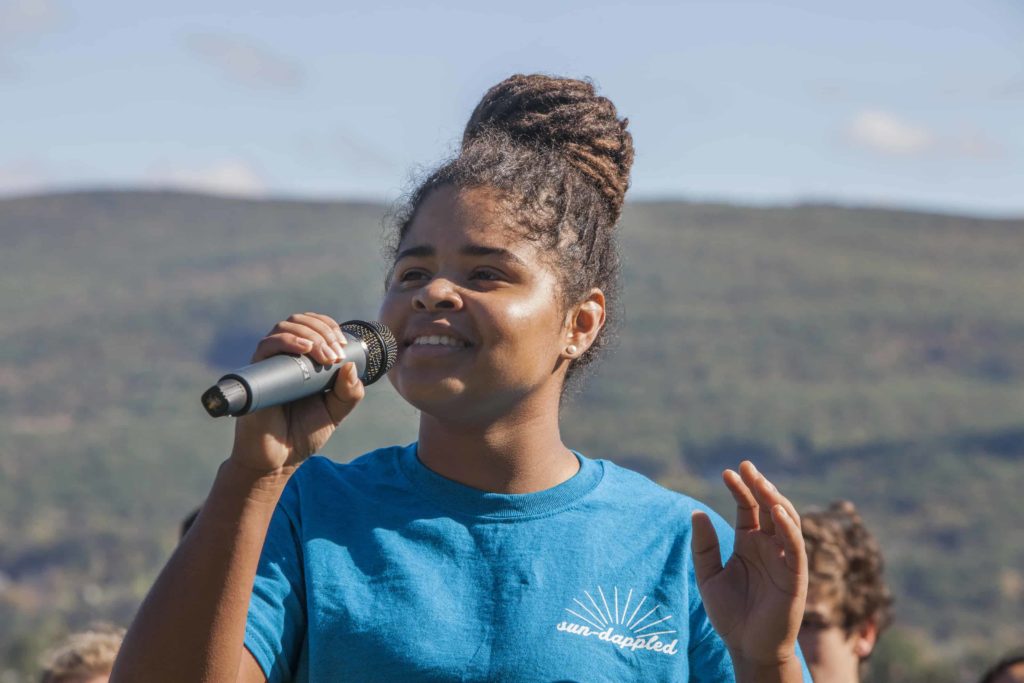 A singer performs on Stony Ledge overlooking Mount Greylock on Mountain Day at Williams College. Students celebrate a fall day with music and outdoor activities.