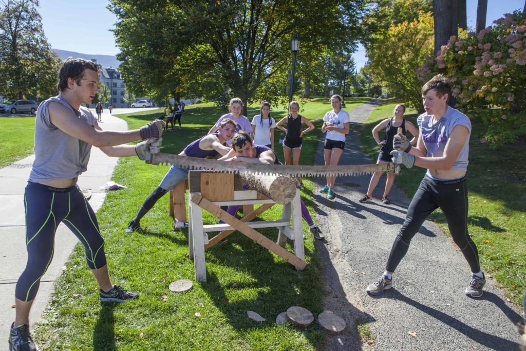 Students try out a crosscut saw on Mountain Day at Williams College. Students celebrate a fall day with music and outdoor activities.