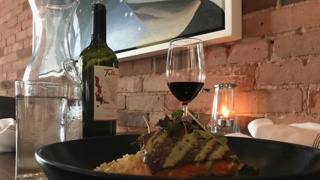 Light flickers on salmon and wine at Public Eat + Drink in North Adams.