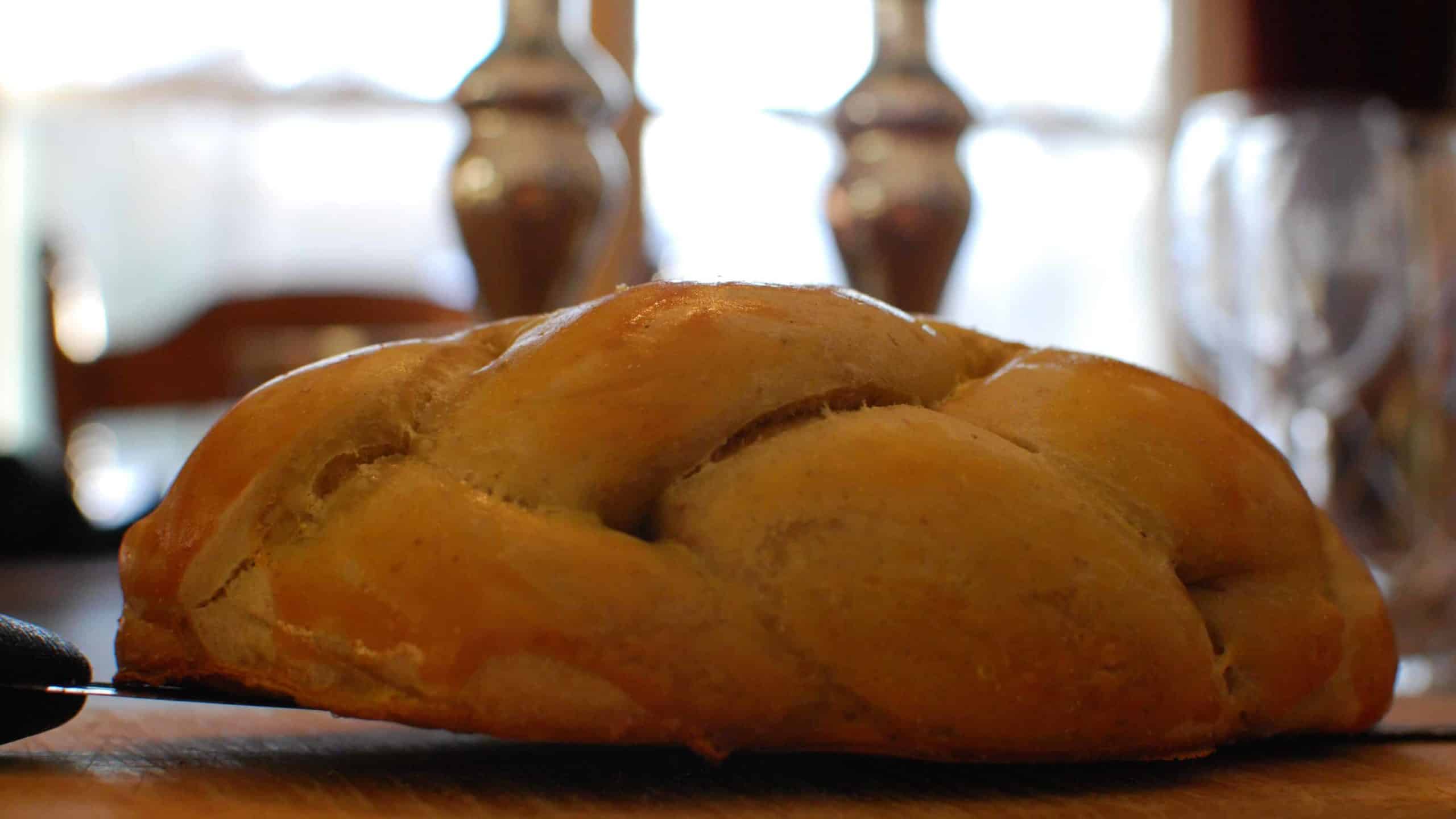 Challah (bread) sits beside candles on the shabbat table. Creative Commons ourtesy photo.