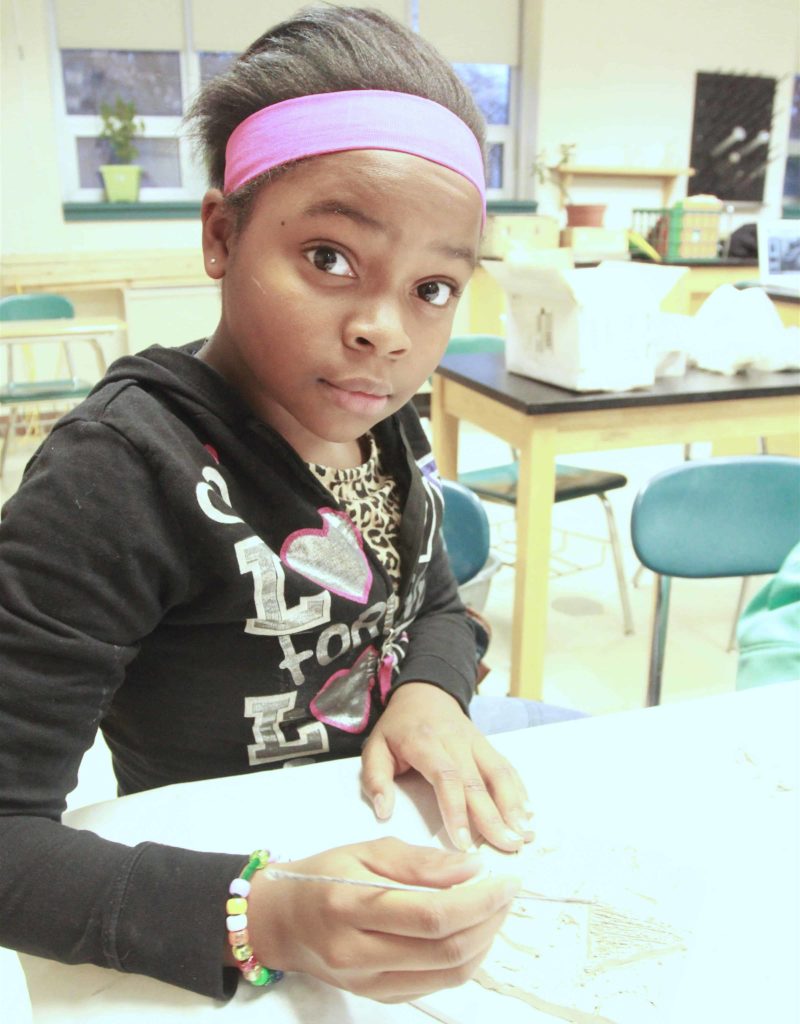 A young artist at Herberg Elementary School gets hands-on in a IS183 class. Image courtesy of IS183
