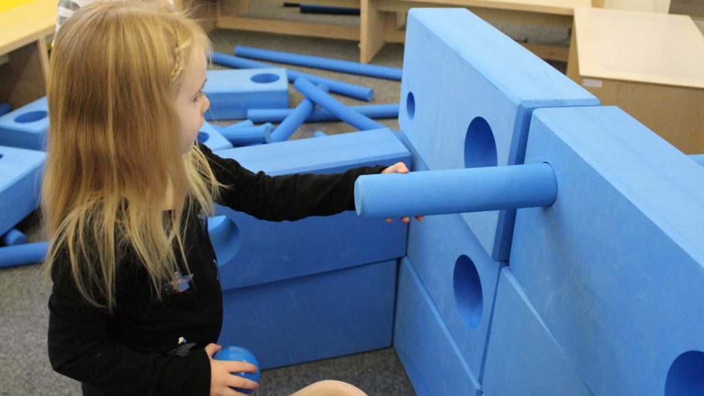 A young visitor experiments with giant blue blocks at the Berkshire Museum.