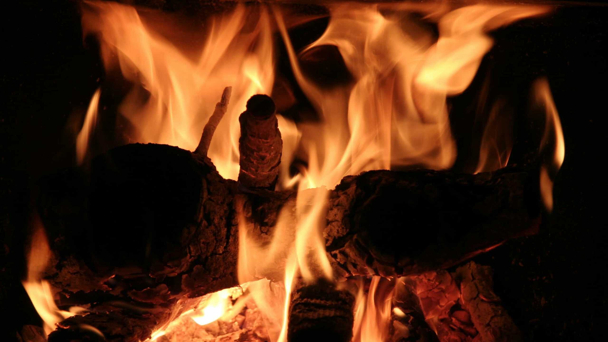 A wood fire blazes in the hearth. Courtesy creative Commons photo.