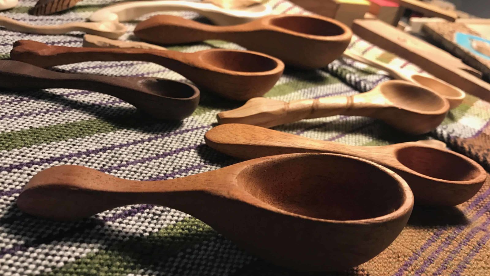Tony Pisano, an artist and woodworker, beekeeper, musician and more in North Adams, carves spoons in a workshop at he has set up at Mass MoCA as part of an exhibit in 2018.