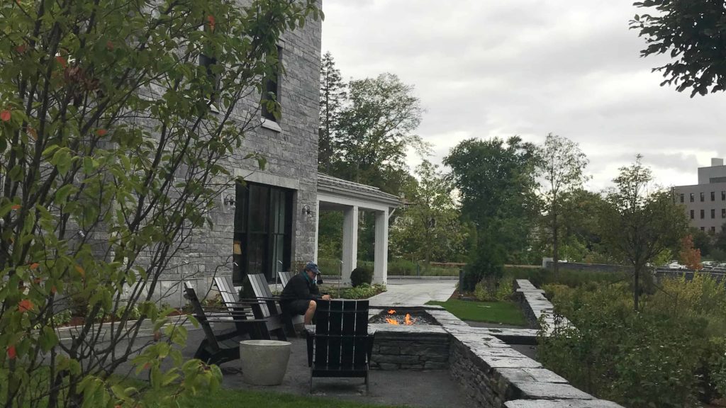 A guest sits by the outdoor fire pit on the terrace at the Williams Inn.