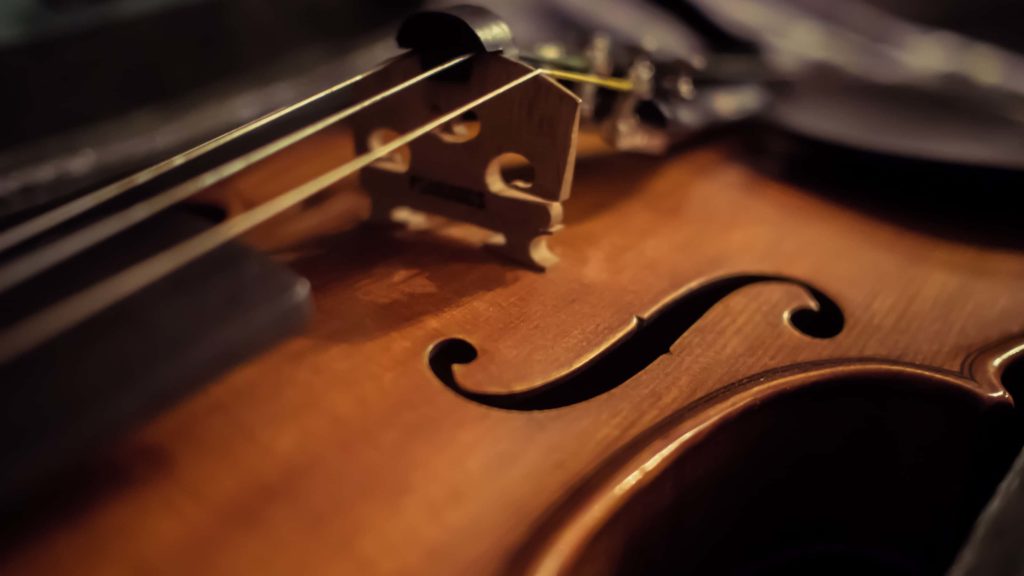 Light touches the f-hole of a violin or fiddle.