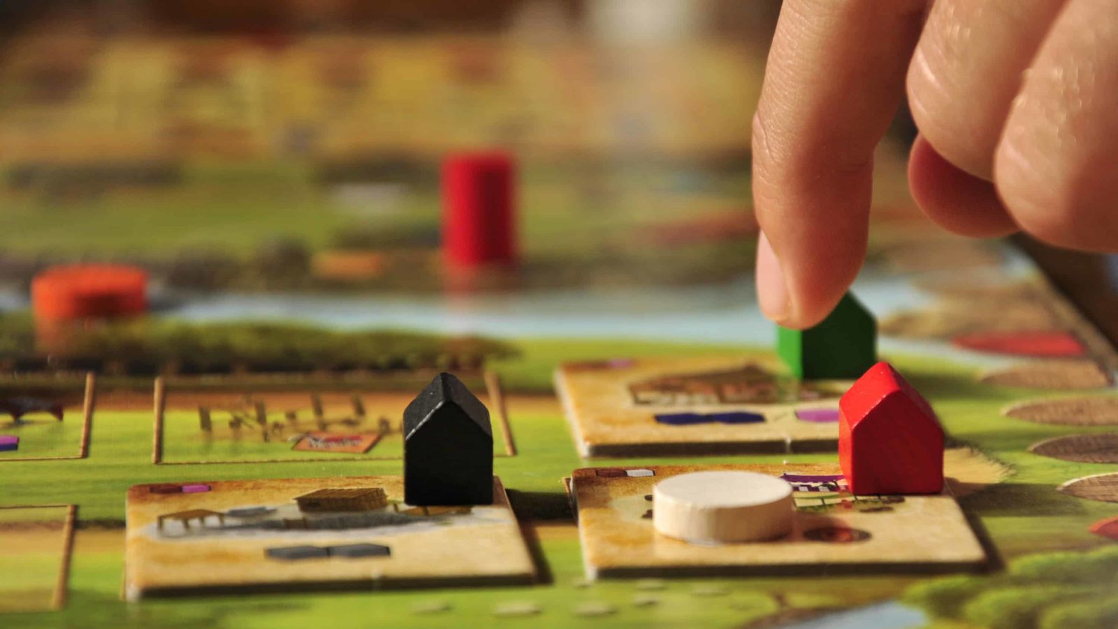 Tiles, tokens and houses set up a game of Caylus.