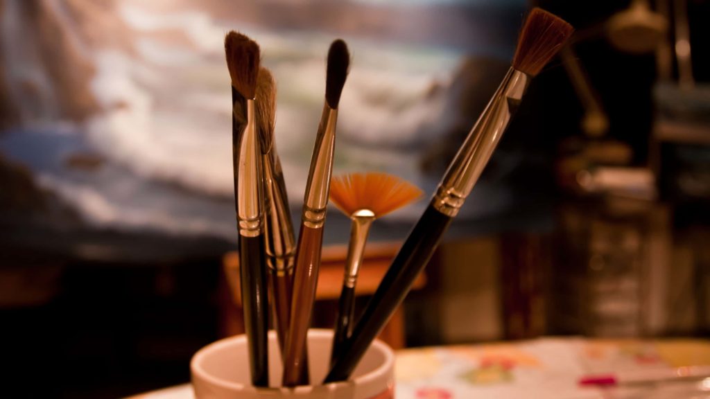 Paint brushes lean in a coffee cup in an artist's studio. Creative Commons courtesy photo.