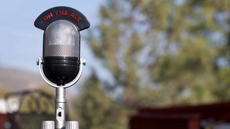 A retro radio mic sits outside on a sunny day.