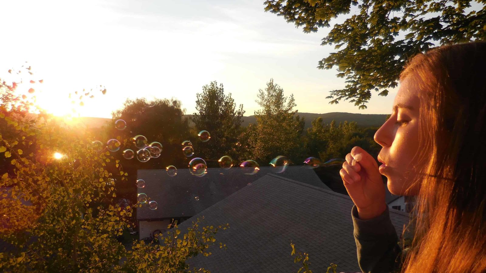 Bellamy Richardson blows bubbles off the porch of bunk 16 in 2016 at Crane Lake Camp.