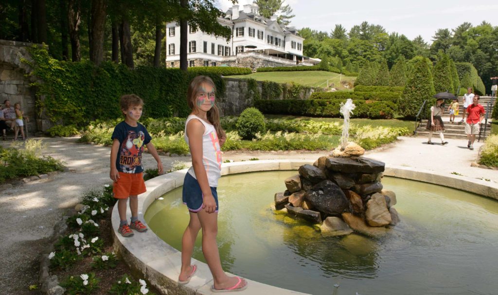 Young visitors look at the fountains at a community garden party at the Mount, Edith Wharton's historic house in Lenox.