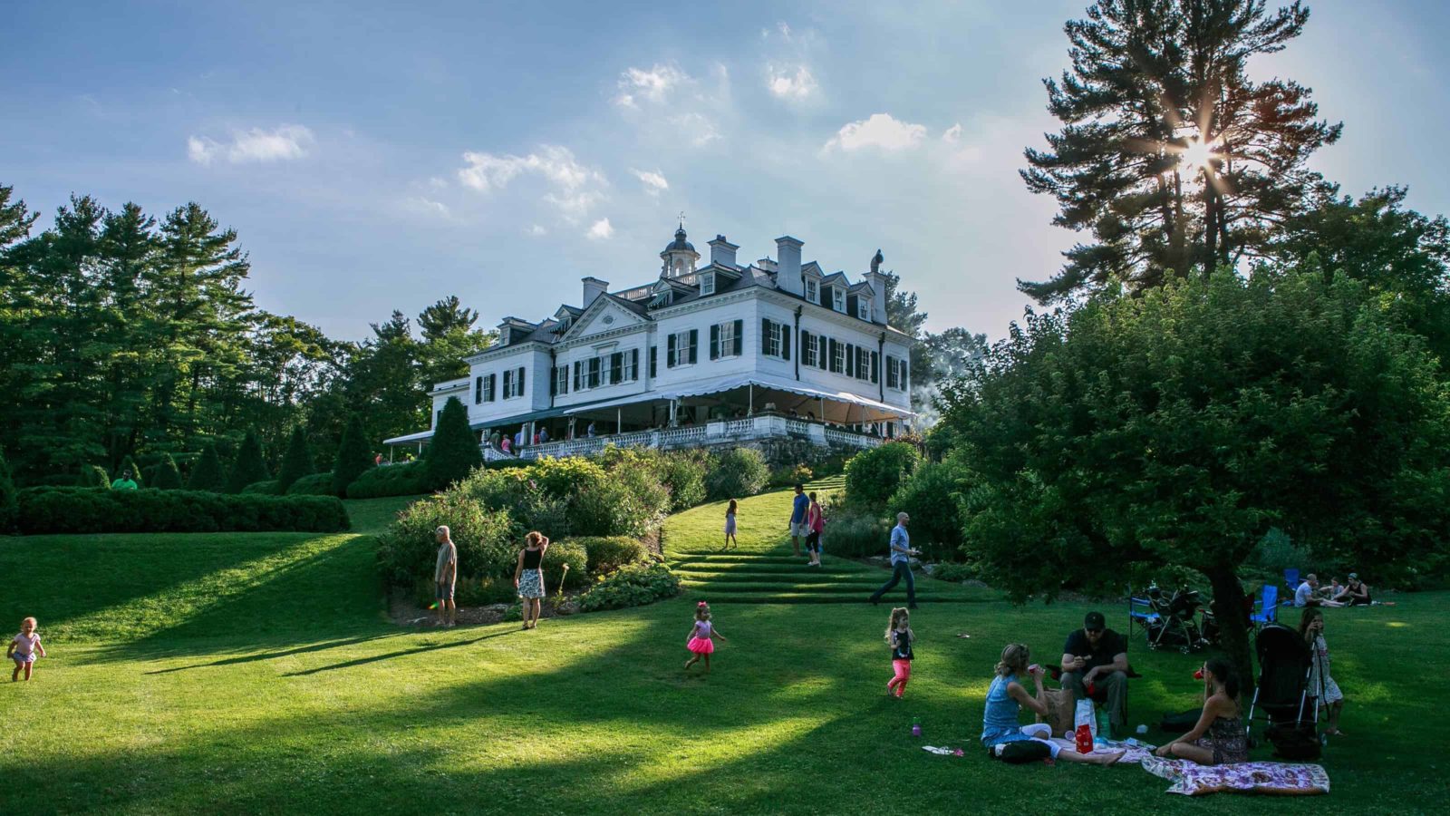 Families picnic on the lawn on a summer evening at the Mount, Edith Wharton's historic house in Lenox.