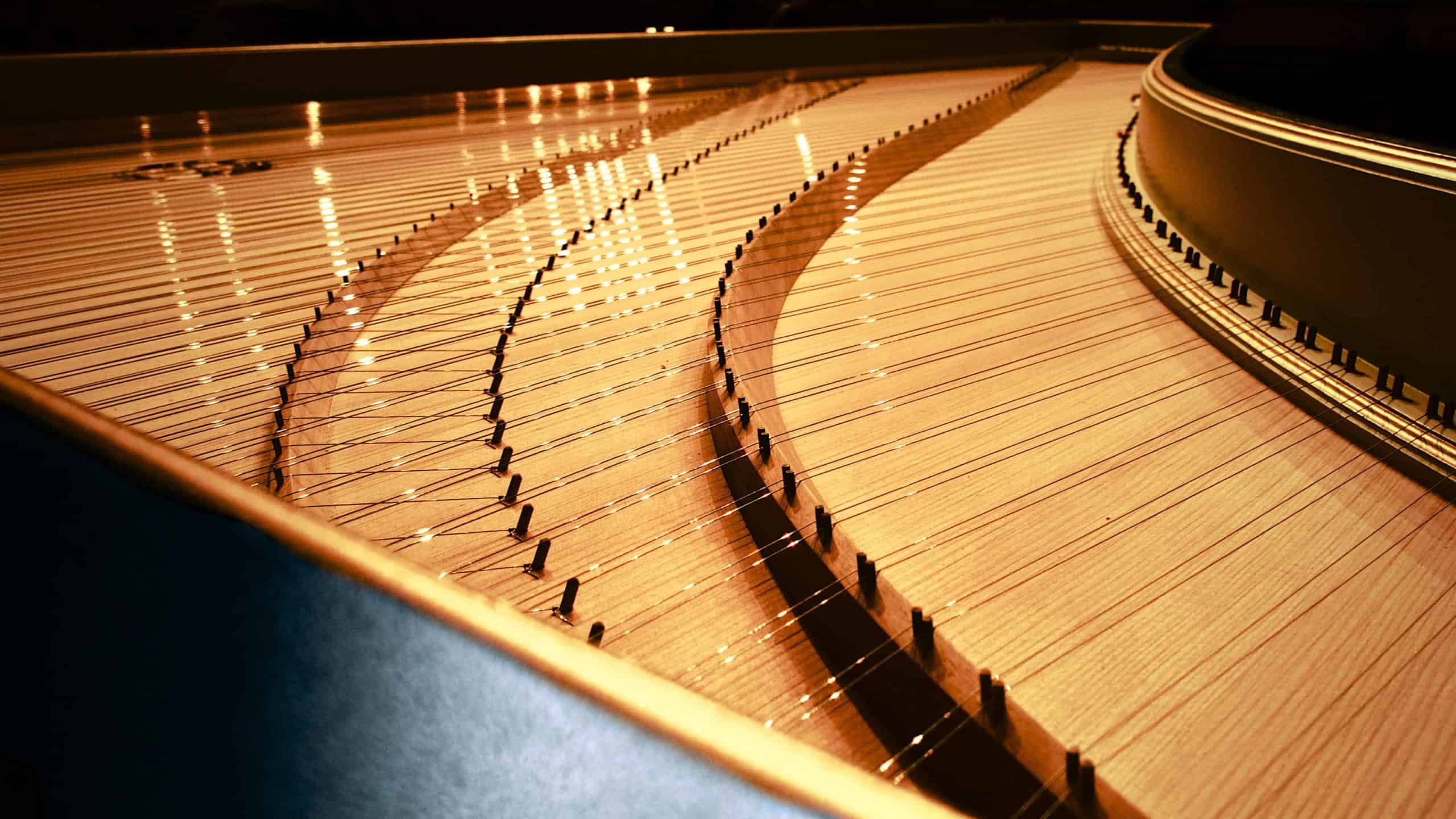 A harpsichord's sounding board curves into the light. Creative commons courtesy photo.