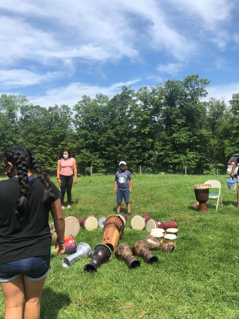 Teachers, youth leaders and students in Multicultural Bridge's Happiness Toolbox program gather in a circle of djembes and talking drums.