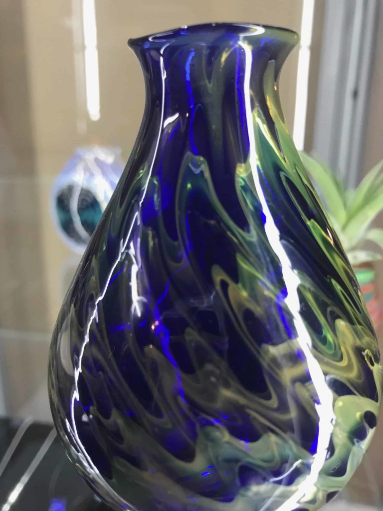 A vase swirles deep blue and meadow green at Cheshire Glassworks.