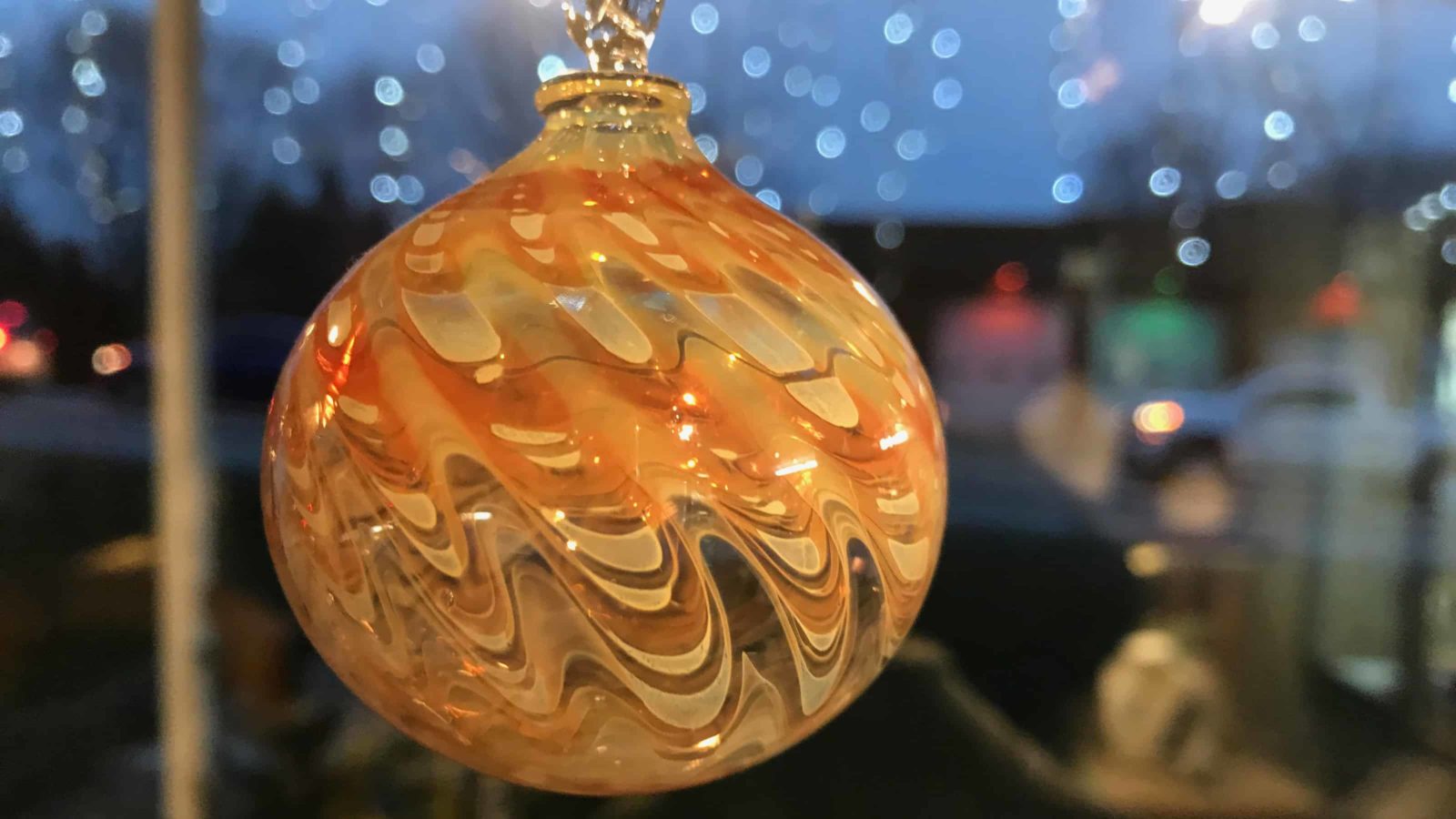 A handmade glass ornament glows warmly at Cheshire Glassworks.