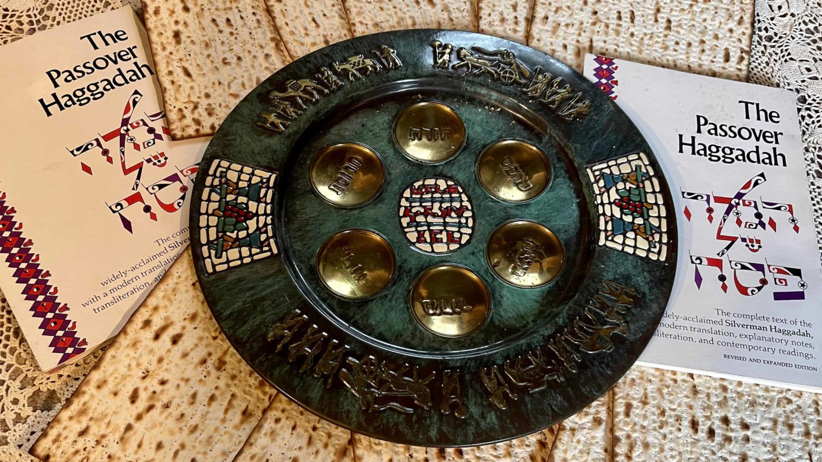 A Seder plate sits in a ring of matzah by a Haggadah for Pesach (Passover).