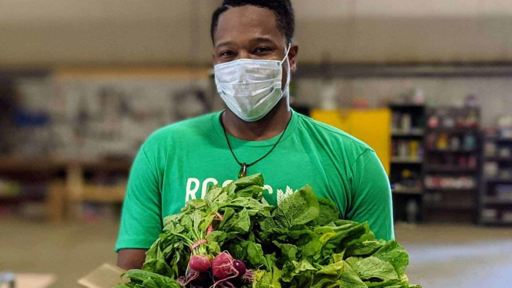 A volunteer with Roots Rising assembles orders for the weekly virtual farmers market in the pandemic. Press photo.