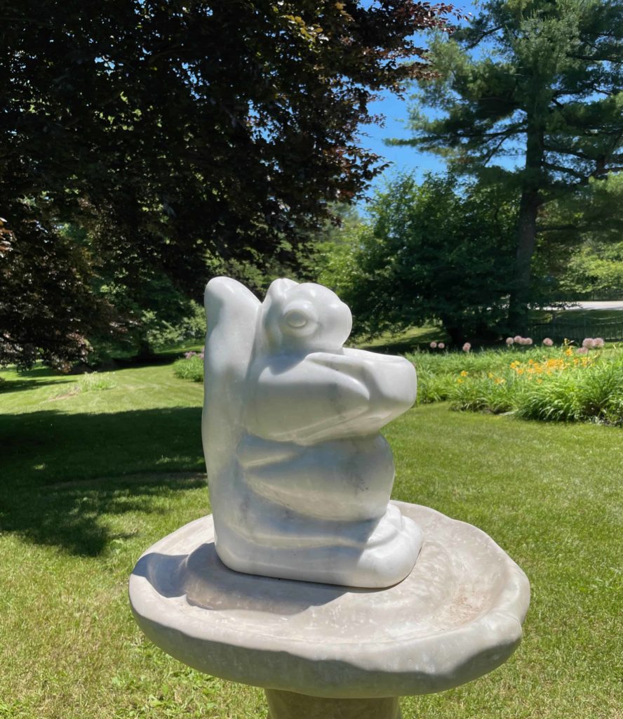 Ian Swordy's curved stone sculptures of squirrel-like creatures catch the light at the Berkshire Botanical Garden.