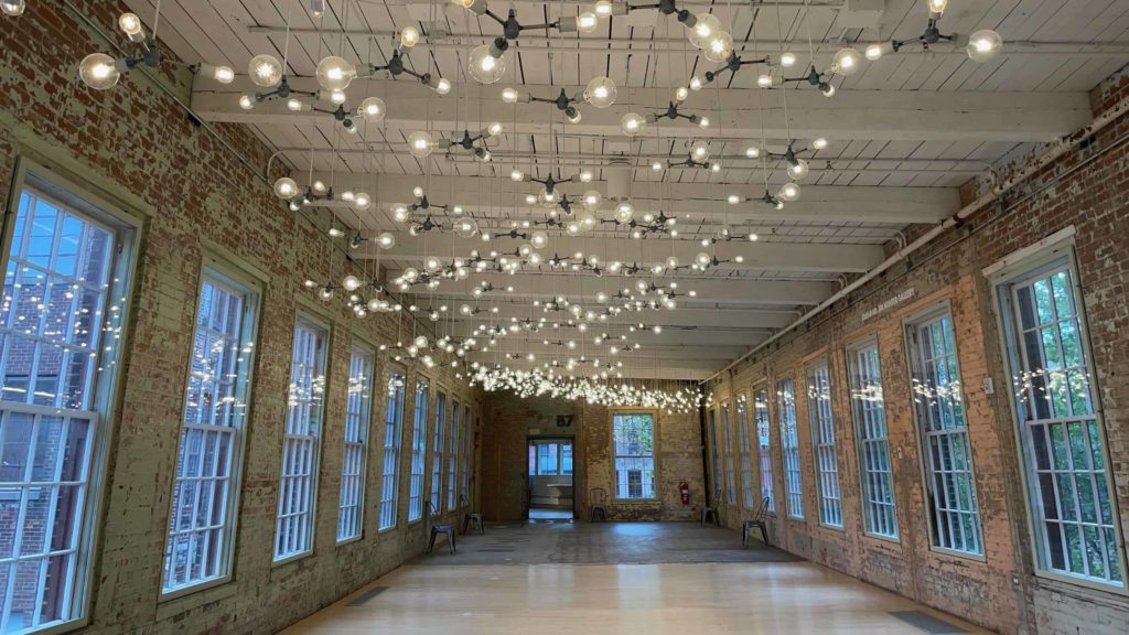 The lights of Cosmic Latte seem to spill out the windows at Mass MoCA.