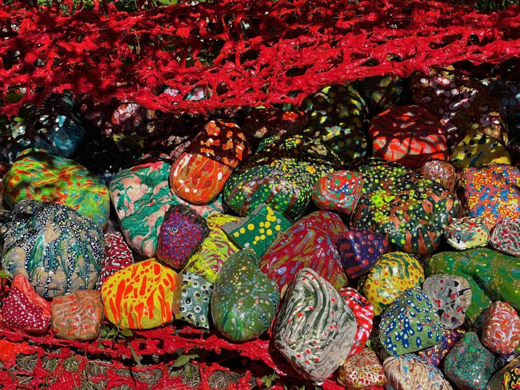 Brightly painted stones fill the red wire frame of Elizabeth Knowles' Shell at the Mount.