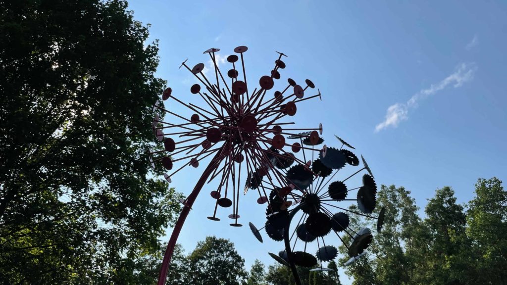Gints Grinbergs' Mega Varieties sculpture looms like giant dandelions against a blue sky in the North Bennington Outdoor Sculpture Show.