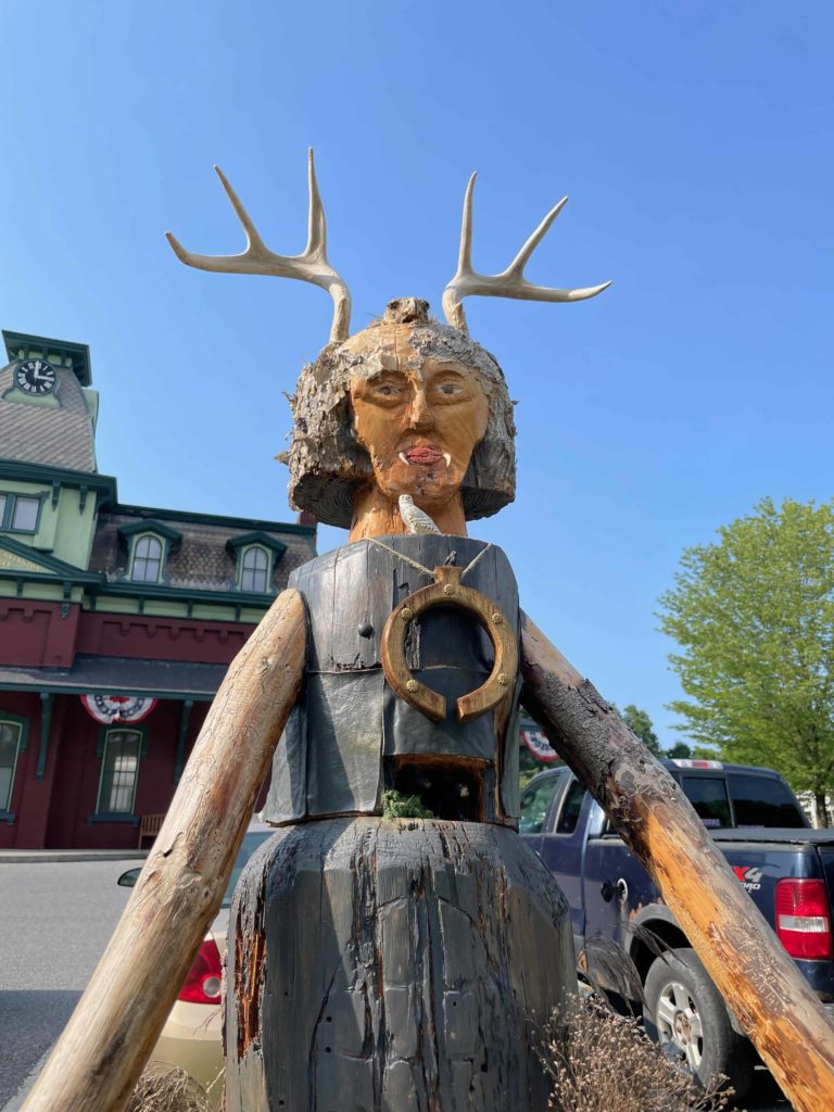 Brian Johnston's horned Cernunnos wood sculpture stands near the town hall in the North Bennington Outdoor Sculpture Show.