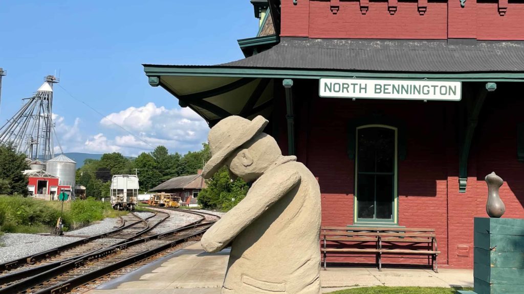 A passenger waits beside the historic train track in the North Bennington Outdoor Sculpture Show.