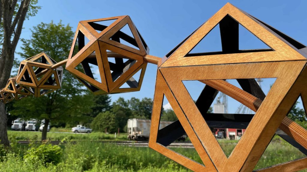 Wooden polyhedrons seem to float like bubbles across the sky in the North Bennington Outdoor Sculpture Show.