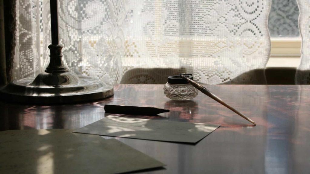Emily Dickinson's desk catches light through a curtain at the Emily Dickinson Museum in Amherst.