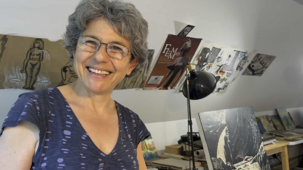 Artist Gloria Calderon Saenz talks in her studio in North Adams with her paintings and prints around her.
