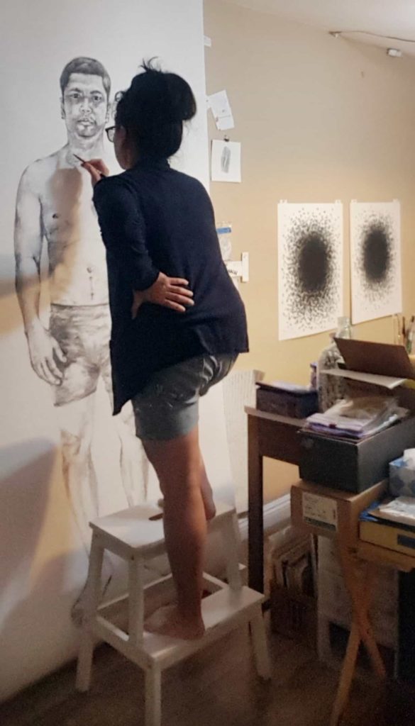 Trinh Mai creates arrows and draws a lifesized portrait of her husband, Hien, for an art installation in her studio in Southern California. Image courtesy of the artist. Images courtesy of the artist