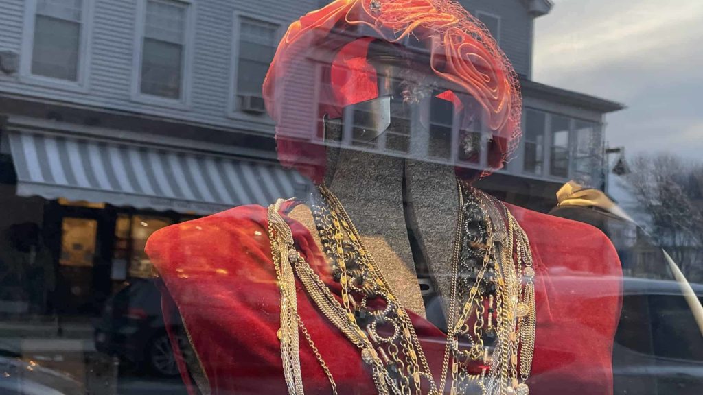 A mannequin wears a red velvet dress in the Bux Vintage window on Spring Street.