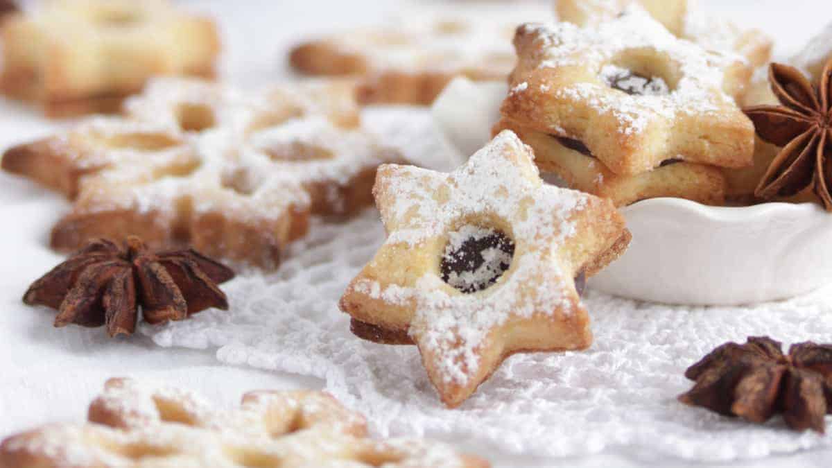 Cardamom cookies in shapes of stars and snowflakes sit on a table dusted with sugar. Creative Commons courtesy photo