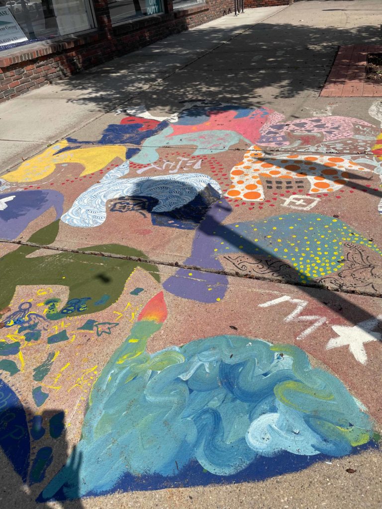 Sidewalk paintings catch the sun on a summer day on Main Street in North Adams.